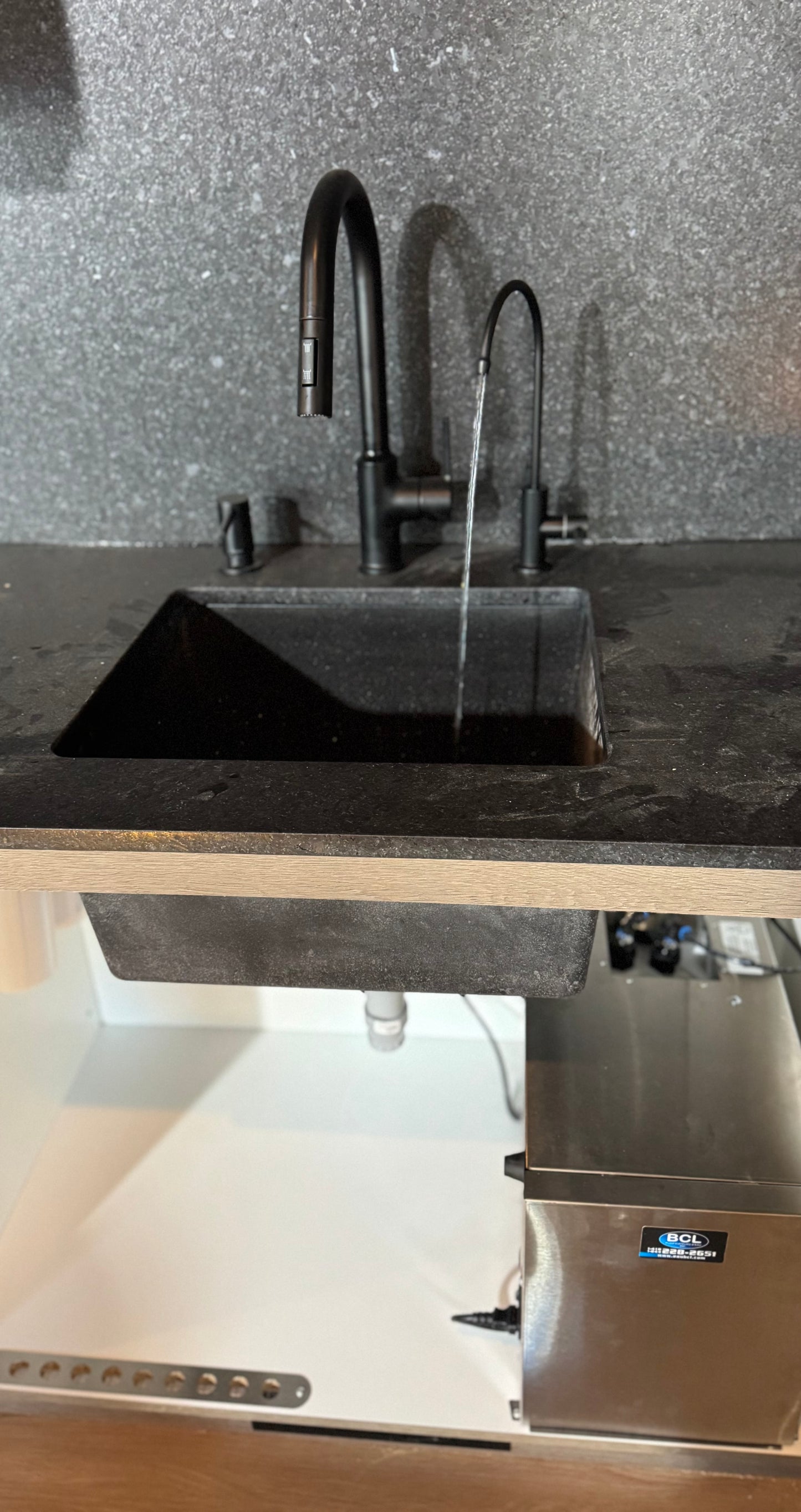 Installation d’un système de filtration sous comptoir avec robinet d’eau filtrée BCL.