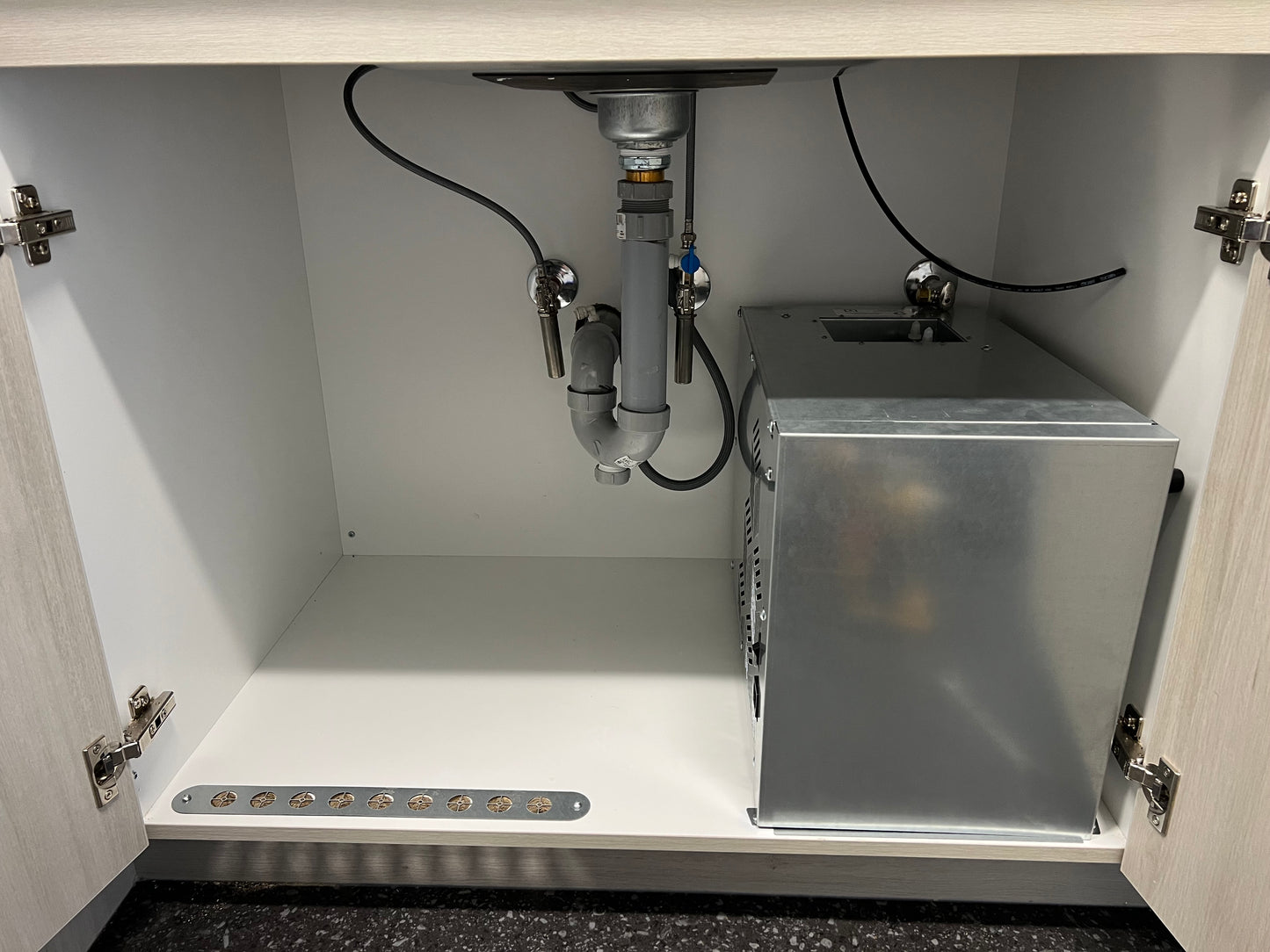 Installation d’un refroidisseur IceBoxx sous comptoir connecté à la plomberie de l’évier.
